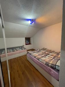 2 camas en una habitación con techo en Perroi Shqiptar, en Deçan