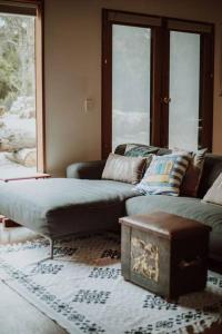sala de estar con sofá y mesa en Three Little Pigs Escape - Main House + Cabin, en South Bruny