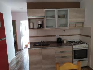 a kitchen with a sink and a stove top oven at Departamento Navarro in Malargüe