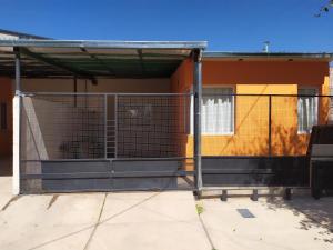 una jaula para perros al lado de un edificio en Departamento Navarro en Malargüe