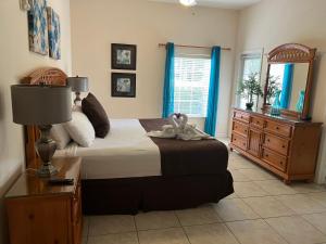 ein Schlafzimmer mit einem Bett, einer Kommode und einem Spiegel in der Unterkunft BAHAMA BAY RESORT in Kissimmee + 43 Fotos