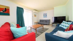 a living room with two couches and a television at Serrell by the Sea in Inverloch