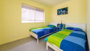 a bedroom with two beds and a window at Serrell by the Sea in Inverloch