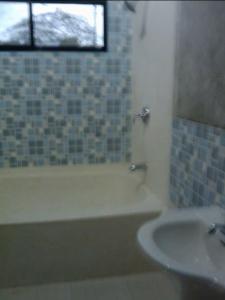 uma casa de banho com uma banheira e um lavatório em DUMA HOSTEL em Dumaguete