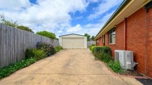 a driveway next to a building with a garage at Serrell By The Sea Free Wifi Pet Friendly in Inverloch