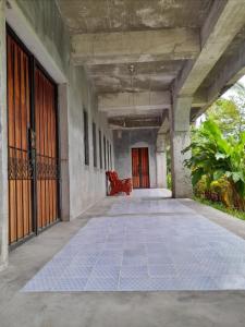 um corredor vazio com uma cadeira vermelha num edifício em DUMA HOSTEL em Dumaguete