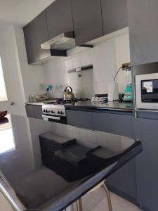 y cocina con encimera, fogones y microondas. en Departamento Familiar Exclusivo 3D, en Valparaíso