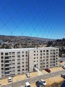 Un gran edificio con coches aparcados en un estacionamiento. en Departamento Familiar Exclusivo 3D, en Valparaíso