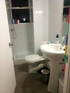 Un baño con lavabo, inodoro y ducha. en Departamento Familiar Exclusivo 3D, en Valparaíso