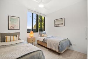 a bedroom with two beds and a window at Seapoint Unit 14 32 Victoria Tce Kings Beach in Caloundra