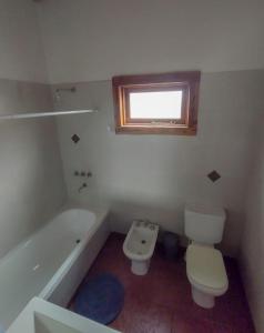 W łazience znajduje się toaleta, wanna i umywalka. w obiekcie Casa El Maiten w mieście El Bolsón