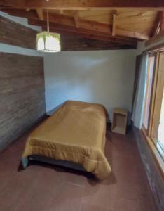 sypialnia z łóżkiem w rogu pokoju w obiekcie Casa El Maiten w mieście El Bolsón