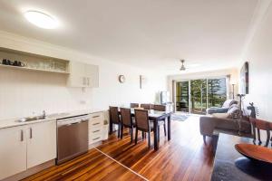a kitchen and living room with a table and chairs at Seaspray 5 in Yamba