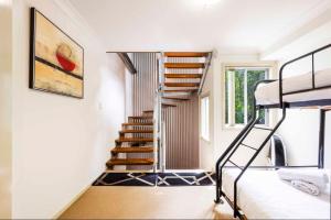 a room with a staircase and a bunk bed at Seaspray 5 in Yamba