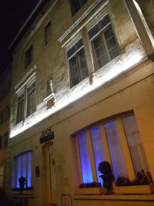 um edifício iluminado à noite com luzes azuis em Hotel de Montaulbain em Verdun-sur-Meuse