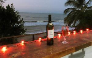 Una botella de vino sentada en una mesa con una copa de vino en Frente al Mar, en Dibulla