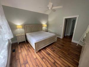 a bedroom with a bed and two tables and a fan at WELCOME TO BURNT RIVER ESTATE in Kawartha Lakes