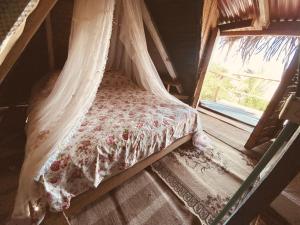 a bed with a canopy in a room with a window at Frente al Mar in Dibulla
