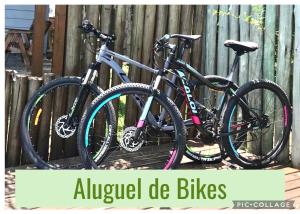 two bikes are parked next to a fence at Pousada Waikiki in Praia do Rosa