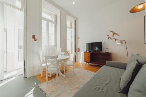 uma sala de estar com um sofá e uma mesa com cadeiras em Porto Downtown Apartments by Vacationy no Porto