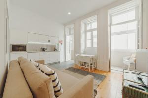 uma sala de estar com um sofá e uma cozinha em Porto Downtown Apartments by Vacationy no Porto