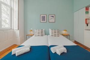uma grande cama branca com duas almofadas em Porto Downtown Apartments by Vacationy no Porto