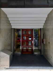 un accès à un bâtiment avec une porte rouge dans l'établissement Cómodo departamento zona casino, à Mar del Plata