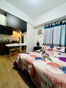 ein Schlafzimmer mit einem Bett und einem Tisch in einem Zimmer in der Unterkunft At Home Condo With Free Pool Access in Manila