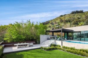 um jardim com piscina e uma casa em Bridle Path Retreat - Christchurch Holiday Homes em Christchurch