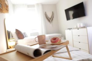 einen Tisch mit einem Teller Donuts und einer Tasse Kaffee in der Unterkunft Vista Apartmani in Ribarska Banja