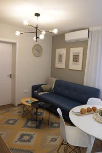 a living room with a blue couch and a table at Vista Apartmani in Ribarska Banja