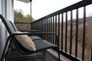 einen Schaukelstuhl auf einem Balkon mit Aussicht in der Unterkunft Vista Apartmani in Ribarska Banja