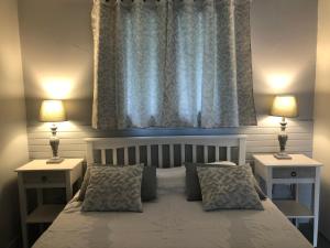 a bedroom with a bed with two nightstands and a window at DUCHARMOY LODGES in Saint-Claude