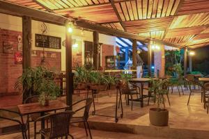 un restaurante con mesas, sillas y plantas en Finca Hotel Casa Nostra, villa Mariana, en Quimbaya