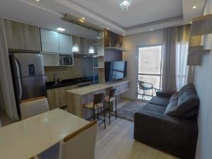 a kitchen and living room with a couch and a table at Apê aconchegante e seguro in Salto