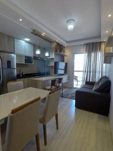 uma cozinha e sala de estar com uma mesa e um sofá em Apê aconchegante e seguro em Salto