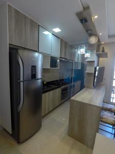 uma cozinha com um frigorífico de aço inoxidável e um balcão em Apê aconchegante e seguro em Salto
