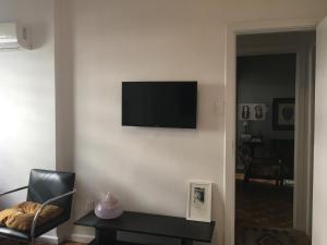 uma sala de estar com televisão numa parede branca em Artist apartment no Rio de Janeiro