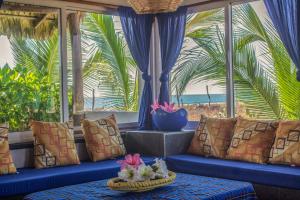 Habitación con sofás azules y vistas a la playa. en Sunset Beachside Villa, en Puerto Escondido