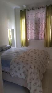 um quarto com uma cama e duas janelas com cortinas em Bem Localizado Apartamento 2 Quartos Orla Rio Vermelho Há 20 min da Barra-Ondina Internet ArCondicionado em Salvador