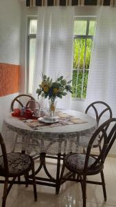 uma mesa com cadeiras e um vaso de flores sobre ela em Bem Localizado Apartamento 2 Quartos Orla Rio Vermelho Há 20 min da Barra-Ondina Internet ArCondicionado em Salvador mais 5 fotografias