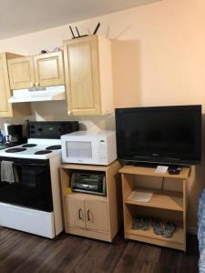 a small kitchen with a stove and a microwave at Shady Willow Guest House -Coach house & Privet Small Compact Rooms with separate entrance in Chilliwack