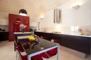 una cocina con una mesa con un bol de fruta. en Villa Matera, en Matera