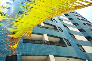 un edificio alto con un edificio amarillo y azul en Apto1003 - Conde da Praia - Vista Mar, en Natal