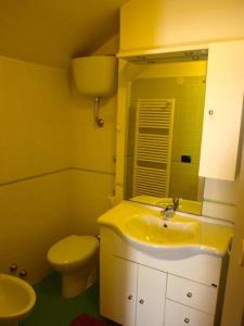 a bathroom with a yellow sink and a toilet at Casa veneto in Montalbano Ionico