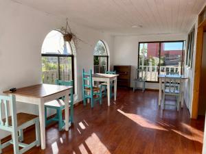 - une salle à manger avec des tables, des chaises et des fenêtres dans l'établissement Hostal Dolegant Pichilemu 2, à Pichilemu