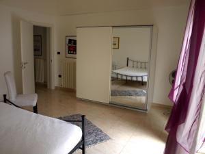 Montalbano JonicoにあるCasa venetoのベッドと椅子付きの部屋の鏡