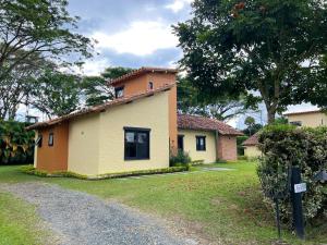 una pequeña casa amarilla con un árbol en Fincas Panaca Villa Portal 9, en Quimbaya