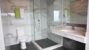 een badkamer met een douche, een toilet en een wastafel bij MaxOneHotels at Jayapura in Jayapura