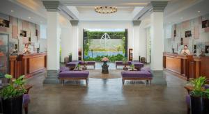 a lobby with purple chairs and a large window at Koulen Hotel in Siem Reap